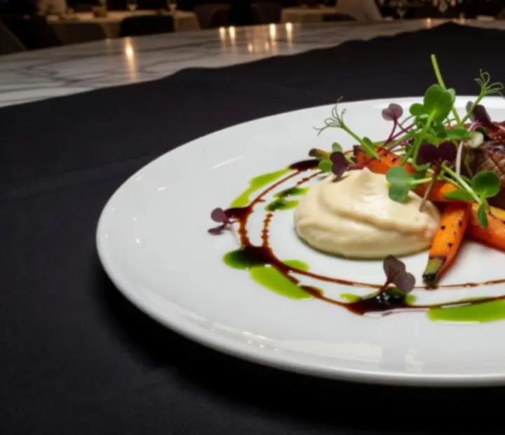 Umjetnički prezentiran tanjur s fine dining jelom u luksuznom ambijentu